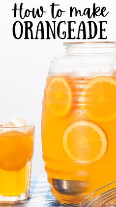 an orangeade drink in a mason jar with two glasses