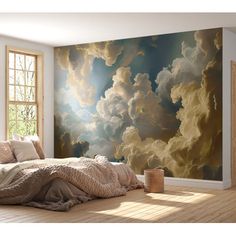 a bedroom scene with focus on the bed and clouds painted on the wall behind it