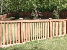 a wooden fence in front of some trees