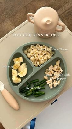 a plate with pasta and vegetables on it next to a teapot, knife and utensils