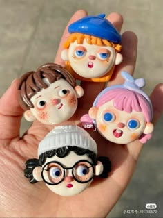 three small figurines in the shape of children's faces on their fingers