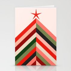 a red star on top of a multicolored striped christmas tree canvas mounted to a wall