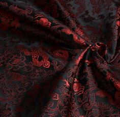 the fabric is red and black with an intricate design on it's back side