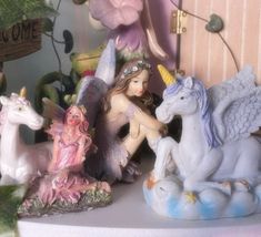 there are many figurines sitting on the shelf in front of each other and one is holding a unicorn