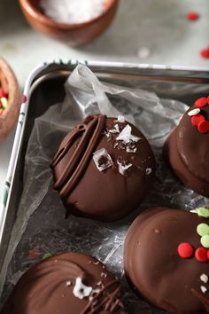 chocolate covered donuts with candy sprinkles on top and in the background