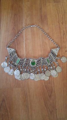 "80's silver tone Afghan Kuchi faux coin choker. There are green glass beads in the centre piece and at the ends, chain clasp at the back. Length in total 23\", at shortest 17 1/2\", width 1 1/2\"" Adjustable Metal Coin Necklace, Round Metal Coin Necklace For Festivals, Silver Round Coin Necklace For Festival, Green Metal Jewelry For Festivals, Silver Coin Necklace For Festival, Green Metal Necklace For Festival, Metal Coin Necklace For Festivals, Vintage Metal Necklace With Coin Pendant, Vintage Nickel Free Choker Necklace