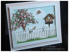 a handmade card with a bird house and tree in the yard on it's side