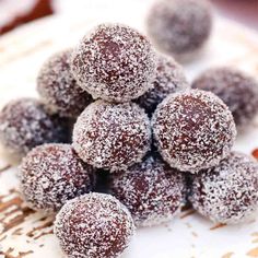 chocolate covered donuts sitting on top of a white plate