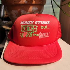 "One size fits all red retro trucker hat with braided band and plastic adjustable sizer. Residue from tape or a sticker above the text but most likely will be removed easily. Text reads \"Money stinks but I love the Smell\"" Red Retro, Trucker Cap, One Size Fits All, Caps Hats, Trucker Hat, Accessories Hats, Baseball Hats, I Love, Baseball