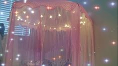 a pink canopy bed with stars on it