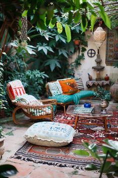 a living room with lots of plants and couches in the middle of it's courtyard