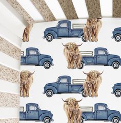 a baby crib with a blue truck and cows on it, next to a wallpaper