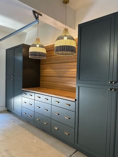 a kitchen with blue cabinets and hanging lights