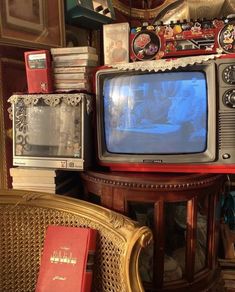 an old tv sitting on top of a wooden table next to a stack of books