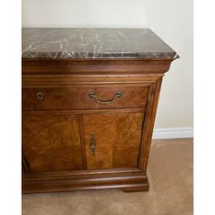 an old wooden dresser with marble top