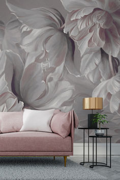 a pink couch sitting in front of a floral wall mural