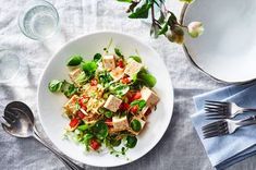 a white plate topped with salad next to silverware