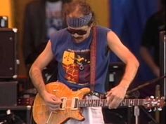 a man playing an electric guitar while wearing blindfolds on his head and glasses