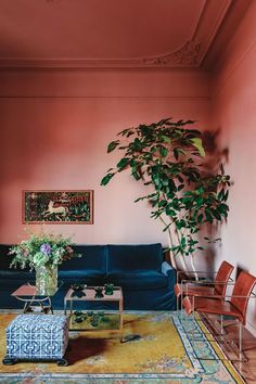 a living room filled with furniture and a potted plant on top of a table