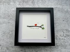 a black frame with a red bird on it and the words i love you written in small letters