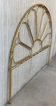 a gold metal headboard against a white wall