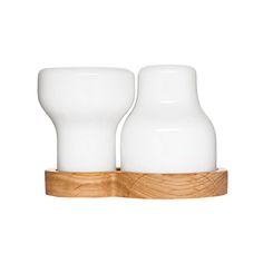 two white vases sitting on top of a wooden holder