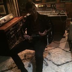 a man sitting in a chair next to a mixing desk