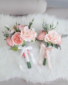 three bouquets of pink flowers are on a white furnishing with ribbons and bows