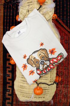 a white shirt with an image of a dog on it and pumpkins around it