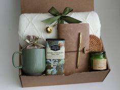 a gift box with coffee, candles, and other items in it sitting on a table