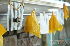 some yellow and white paper hanging from a clothes line