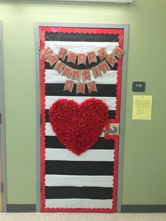 a door decorated with red and black stripes and a heart hanging from the front entrance