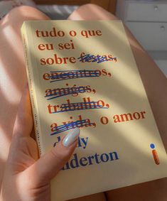 a person is holding a book in their hand with spanish writing on the front cover