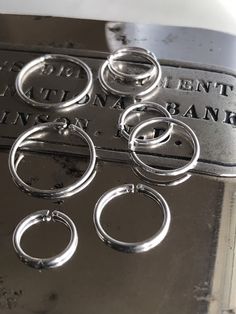 six silver rings are sitting on top of a metal box