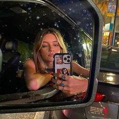 a woman taking a selfie in the back seat of a car with her cell phone