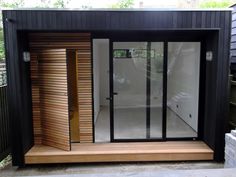 an outdoor room with sliding glass doors on the outside and wooden steps leading up to it