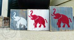 three wooden blocks with elephants painted on them sitting in front of a door and window