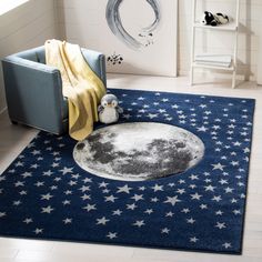 a blue area rug with stars and a moon on the floor next to a chair