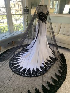 a white and black wedding dress on display in a room