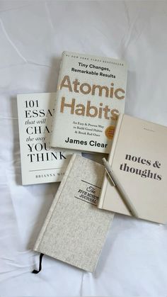 three books sitting on top of a bed next to each other