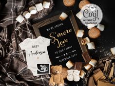 a baby announcement with marshmallows, cookies and a teddy bear next to it