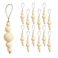 several wooden beads hanging from strings on a white background