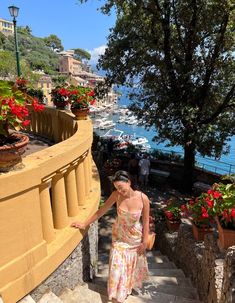 a woman is walking up some steps by the water