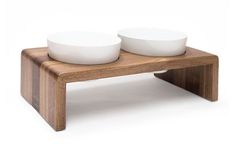 two bowls sit on top of a wooden stand