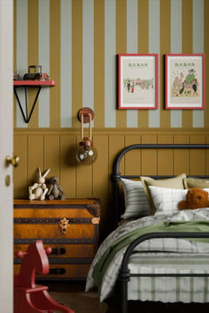 a bed room with a neatly made bed and two pictures on the wall