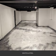 an empty parking garage with white walls and black flooring is seen in this image