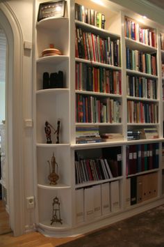 a bookshelf filled with lots of books next to a doorway