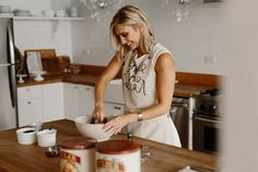 a woman is mixing something in a bowl