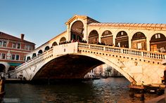 a bridge over water with people walking on it