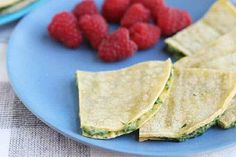 there are raspberries and tortilla chips on the blue plate next to each other